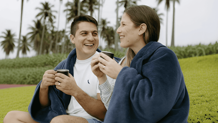 A man and a woman sitting on a beach.